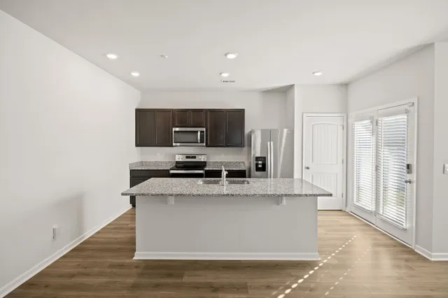 a kitchen with stainless steel appliances granite countertop a refrigerator stove microwave and sink