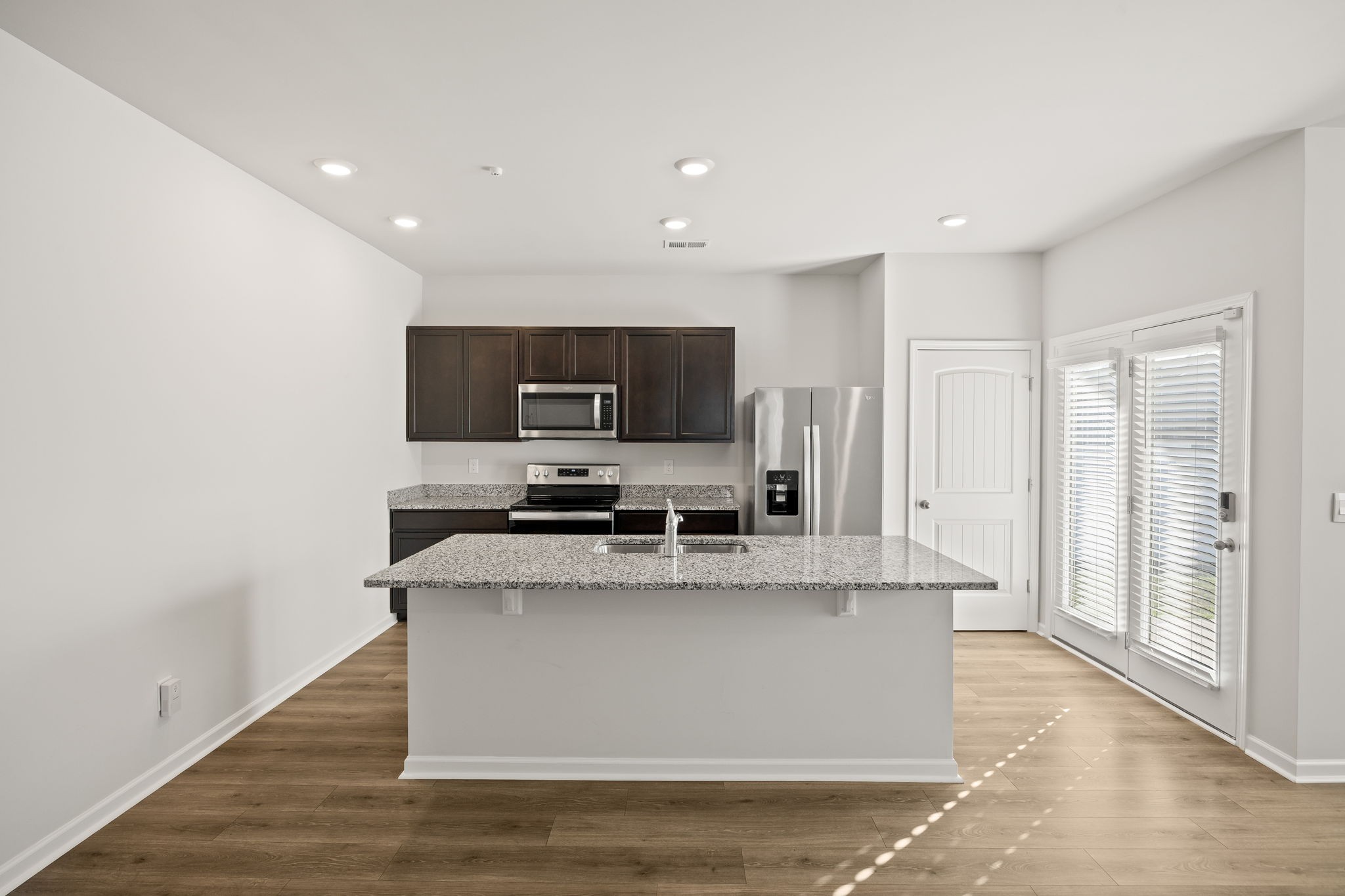 312 Oliver Way Baxter, TN 38544 - Photo 5 of 33 a large kitchen with stainless steel appliances granite countertop a stove a sink dishwasher a refrigerator and microwave with wooden floor