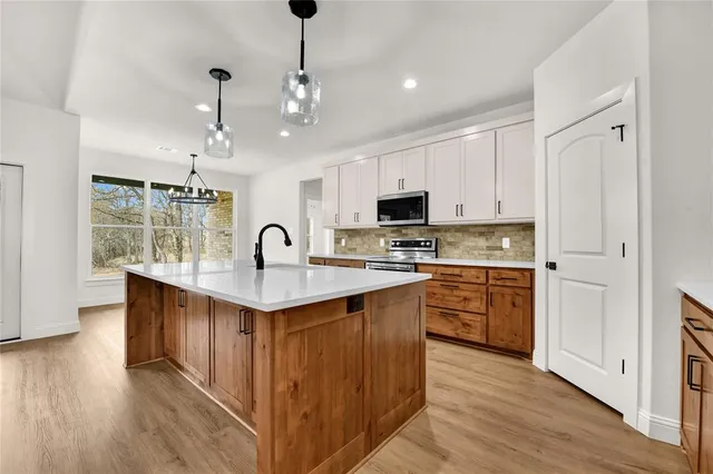a kitchen with stainless steel appliances granite countertop a stove and wooden floor