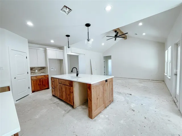 a large kitchen with stainless steel appliances a sink and cabinets