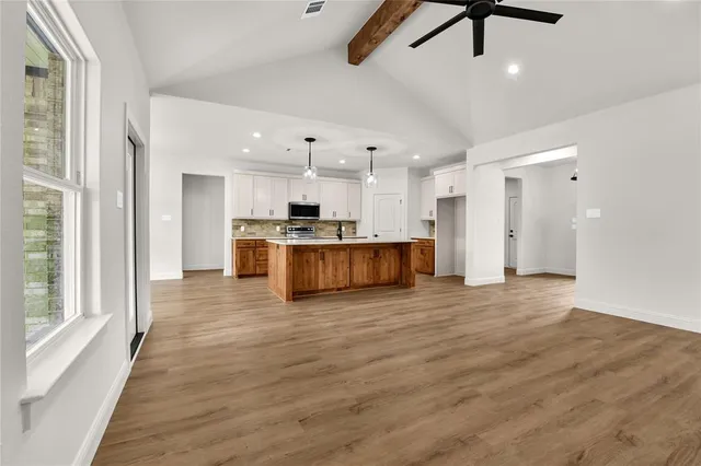 a view of kitchen with refrigerator stove microwave and cabinets