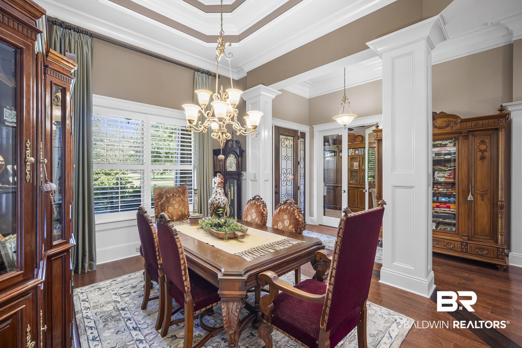 25212 Austin Road Daphne, AL 36526 - Photo 13 of 56 Dining area featuring dark wood-style floors, a chandelier, ornate columns, crown molding, and french doors