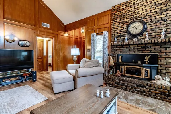 a living room with furniture a flat screen tv and a fireplace
