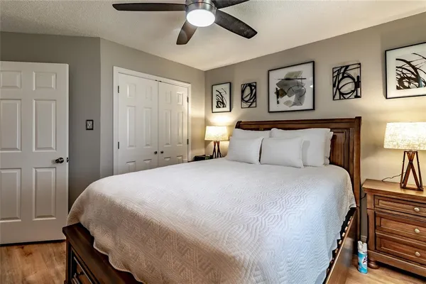 a bedroom with a bed and a large mirror on the dresser