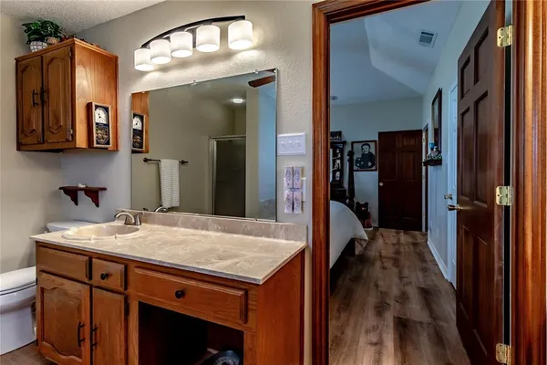 a spacious bathroom with a granite countertop sink mirror and bathtub