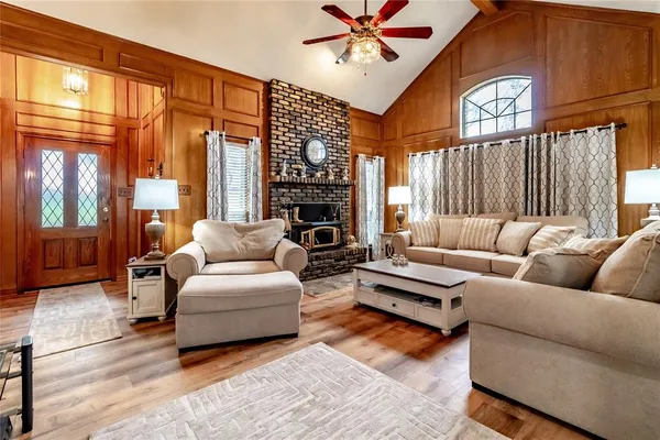 a living room with furniture a flat screen tv and a fireplace