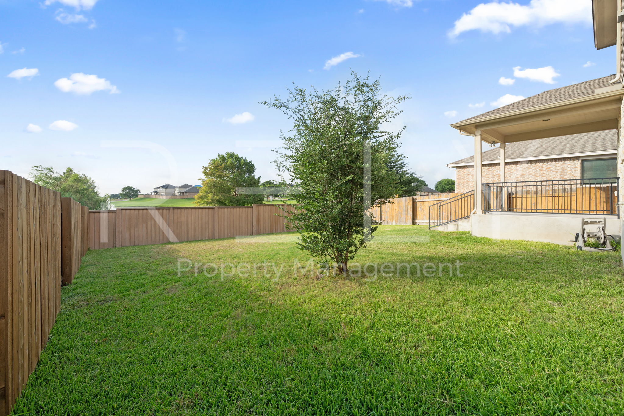 1405 Sunny Meadows Loop Georgetown, TX 78626 - Photo 40 of 40 A well-maintained lawn stretches to a privacy fence, offering a tranquil backdrop to a home's exterior patio.