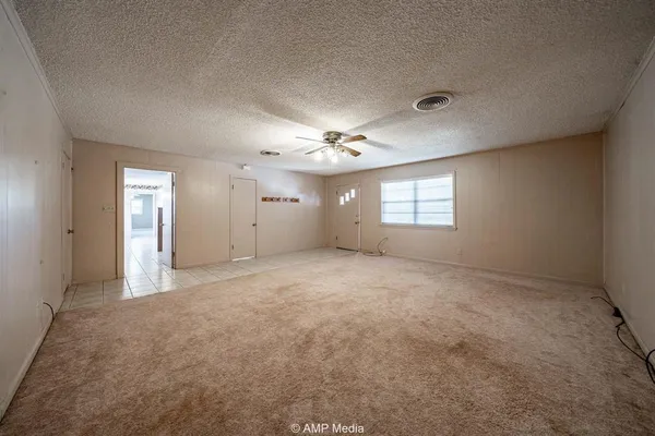 a view of a big room with windows and chandelier fan