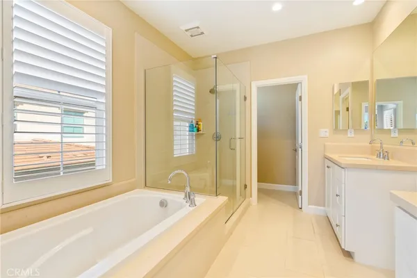 a spacious bathroom with a tub sink and mirror