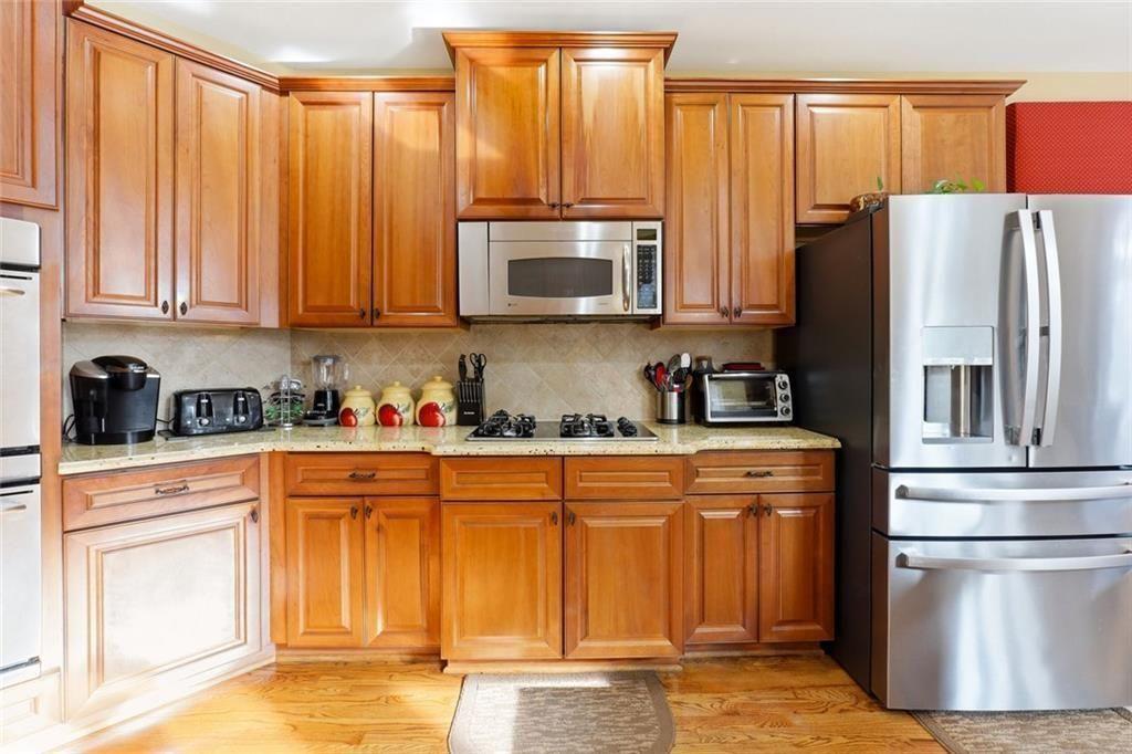 1915 Brackendale Road Northwest Kennesaw, GA 30152 - Photo 6 of 69 a kitchen with stainless steel appliances granite countertop a refrigerator a stove a sink and dishwasher with wooden floor