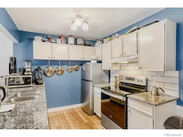 a kitchen with stainless steel appliances granite countertop a stove a sink and a refrigerator