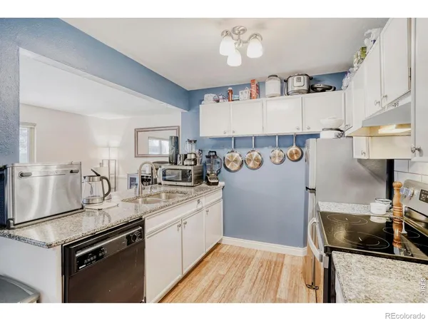 a kitchen with granite countertop a sink stove and refrigerator