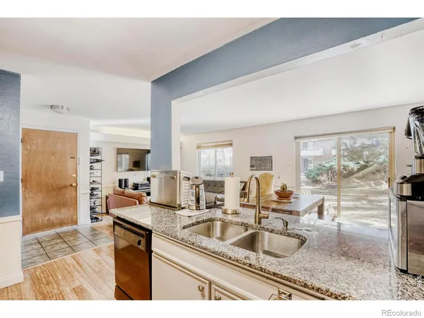 a kitchen with granite countertop a sink stove and cabinets