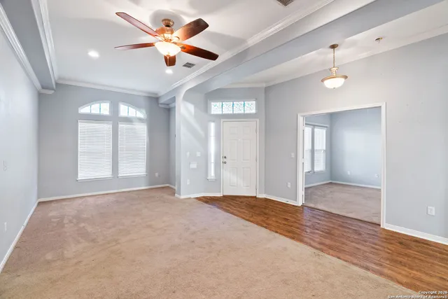wooden floor in an empty room with a ceiling fan