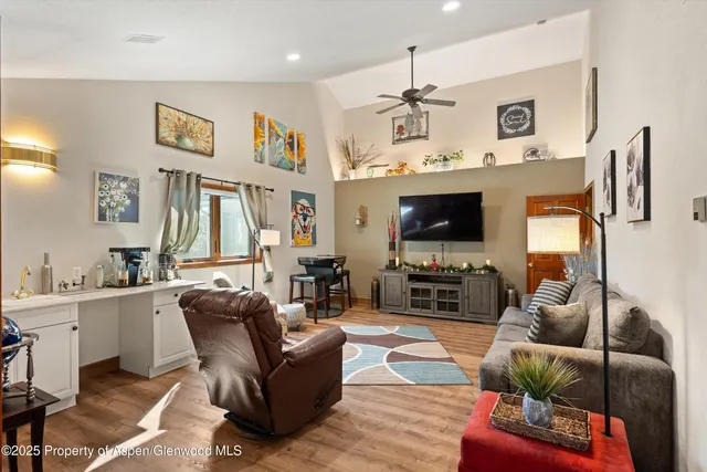 a bedroom with a bed a dresser and large window