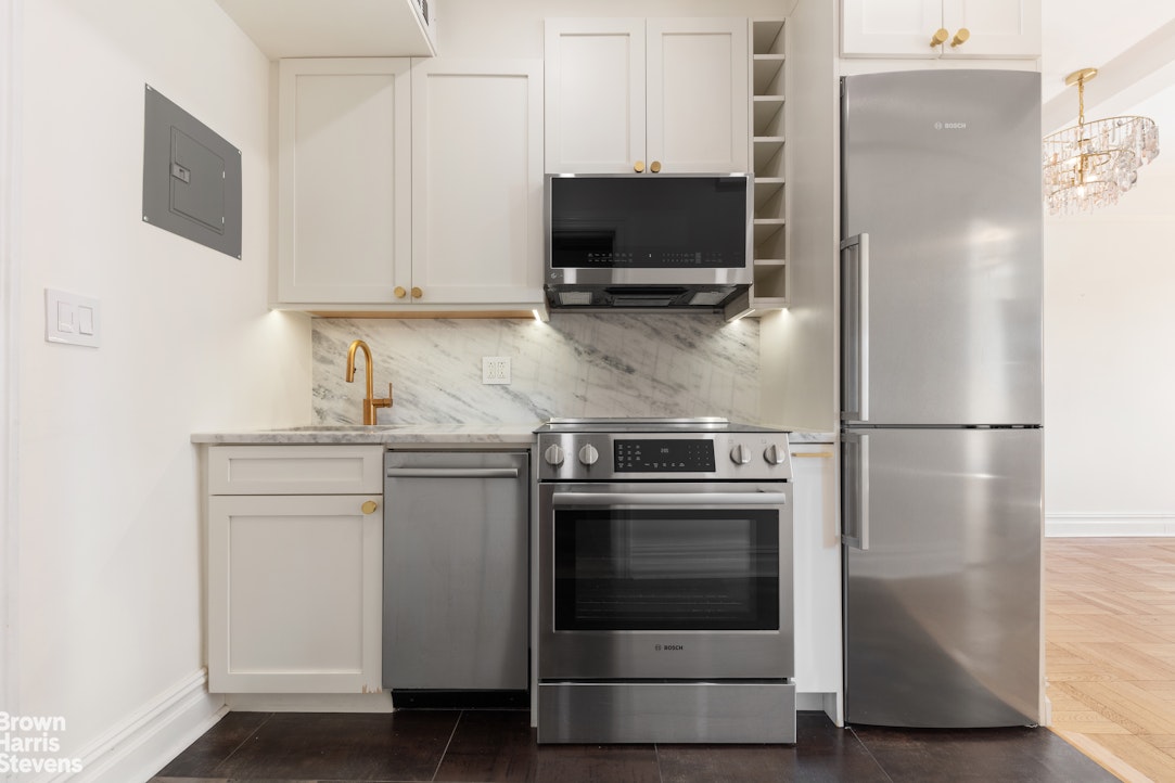 24 5th Avenue, Unit 909 Manhattan, NY 10011 - Photo 3 of 11 a kitchen with stainless steel appliances a refrigerator stove and microwave