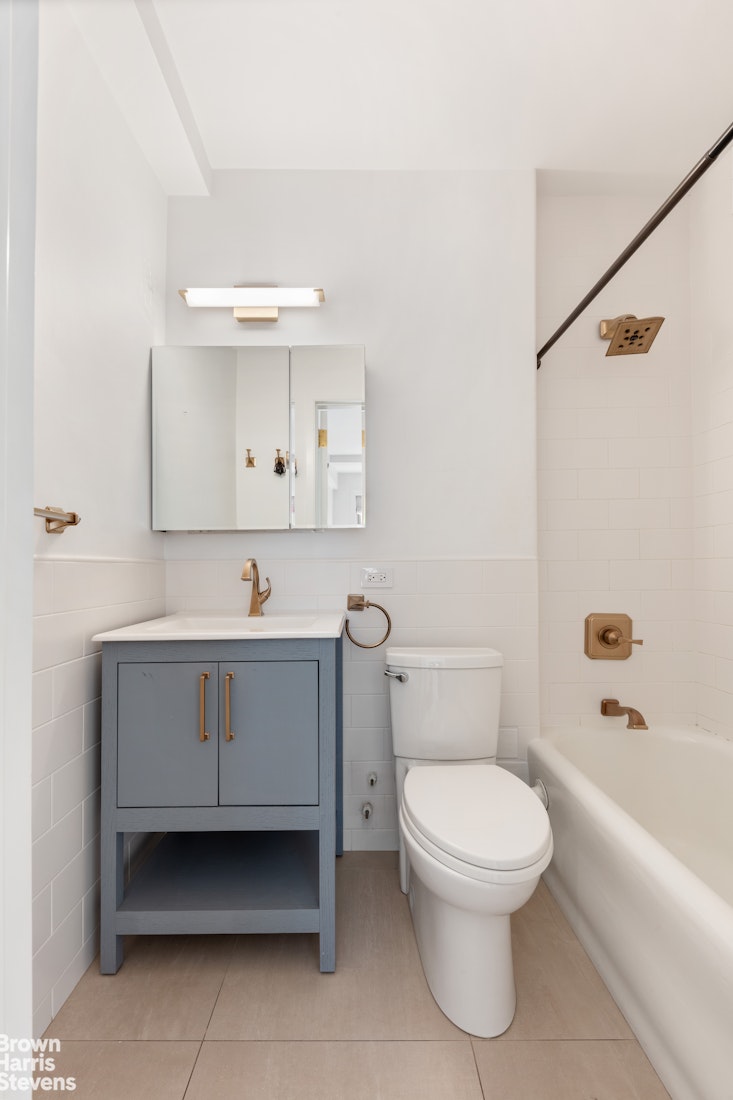 24 5th Avenue, Unit 909 Manhattan, NY 10011 - Photo 7 of 11 a bathroom with a sink a toilet and bathtub