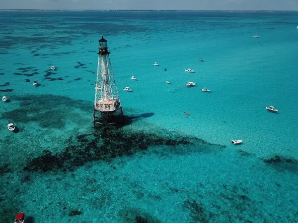 a view of a lake with lawn chairs and a yard
