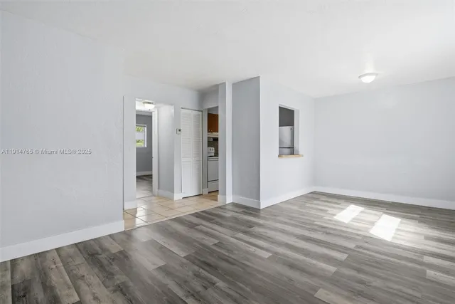 a view of empty room with wooden floor