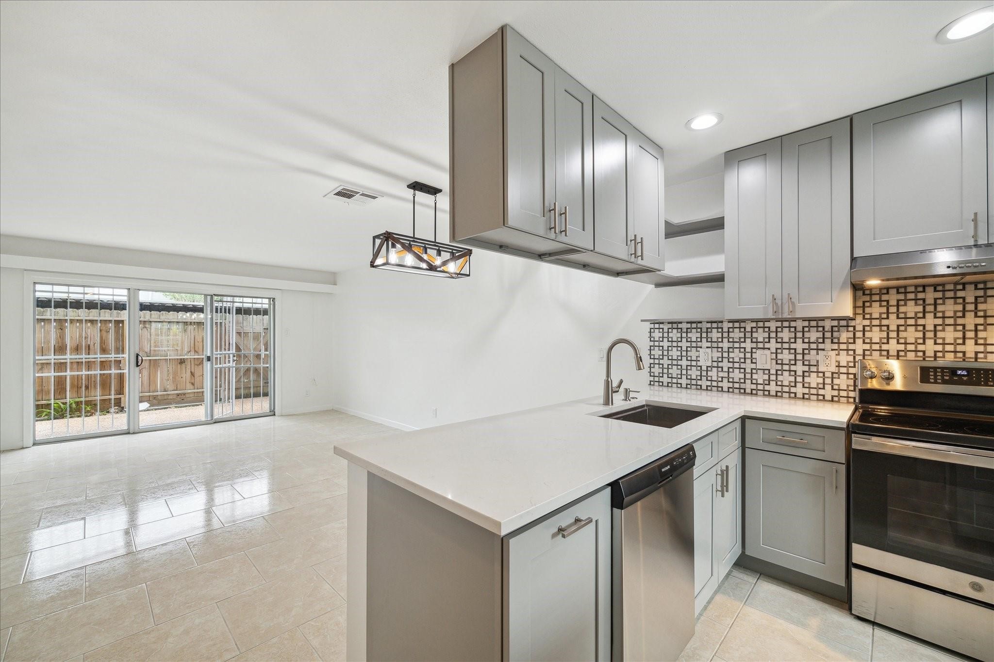 7821 Rue St Cyr Street, Unit 55 Houston, TX 77074 - Photo 4 of 16 Modern kitchen with breakfast bar and stainless steel appliances.
