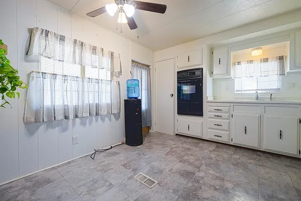 a kitchen with white cabinets and refrigerator