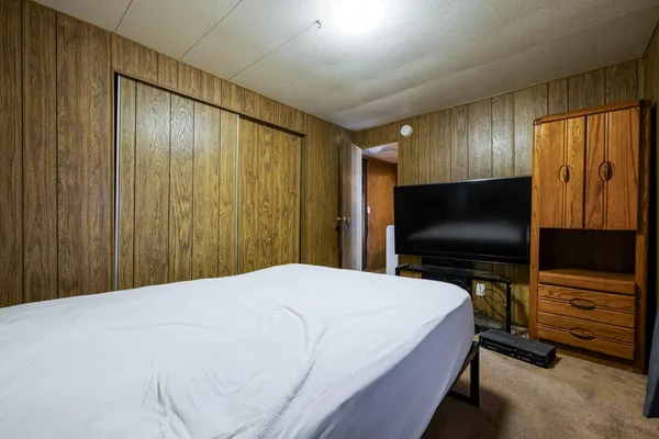 a bedroom with a bed and a flat screen tv