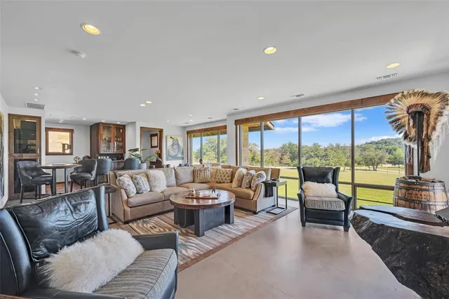 a kitchen with stainless steel appliances kitchen island granite countertop a table chairs and a refrigerator