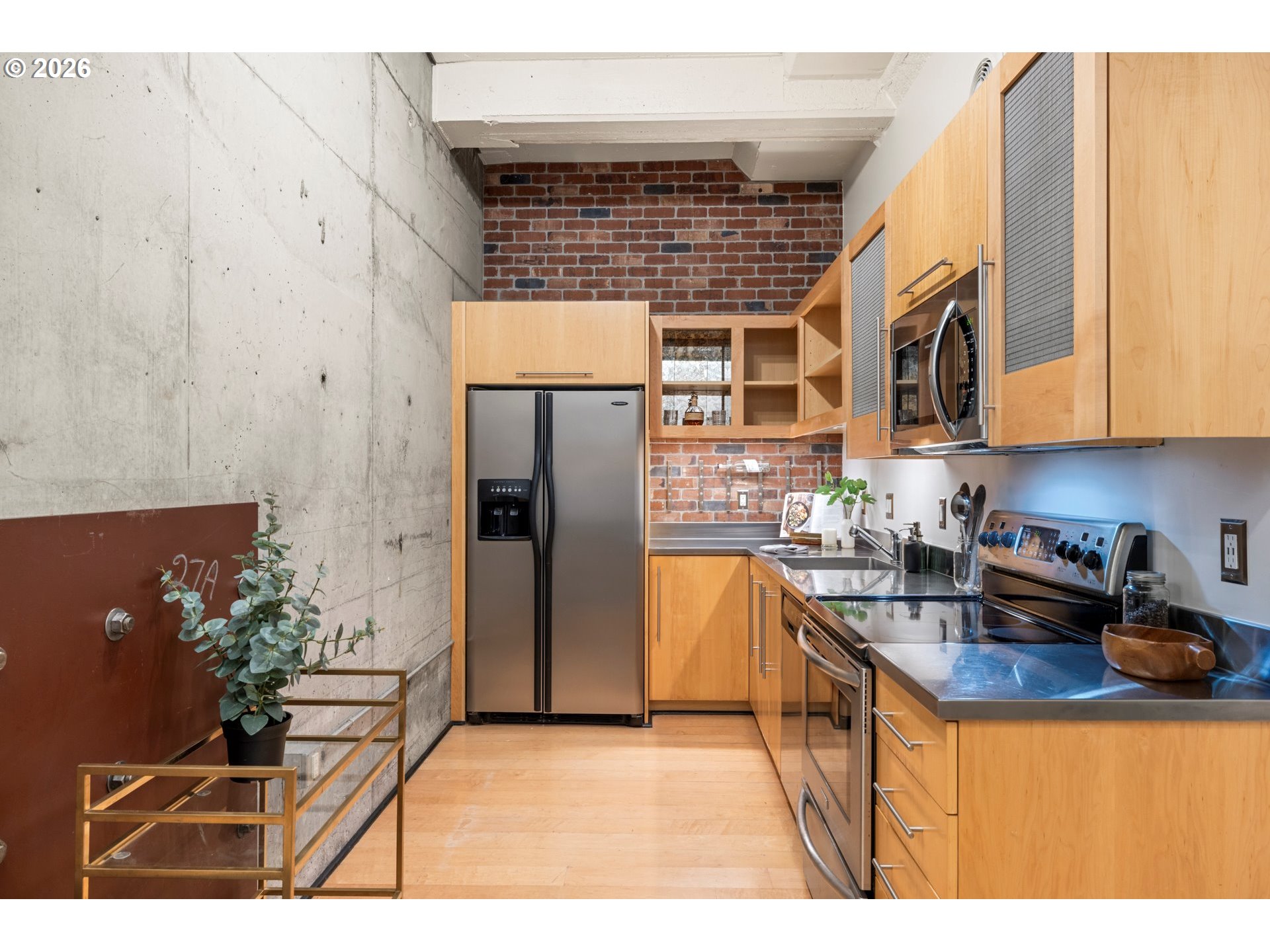 1400 Northwest Irving Street, Unit 322 Portland, OR 97209 - Photo 5 of 27 a kitchen with stainless steel appliances granite countertop a refrigerator and a sink
