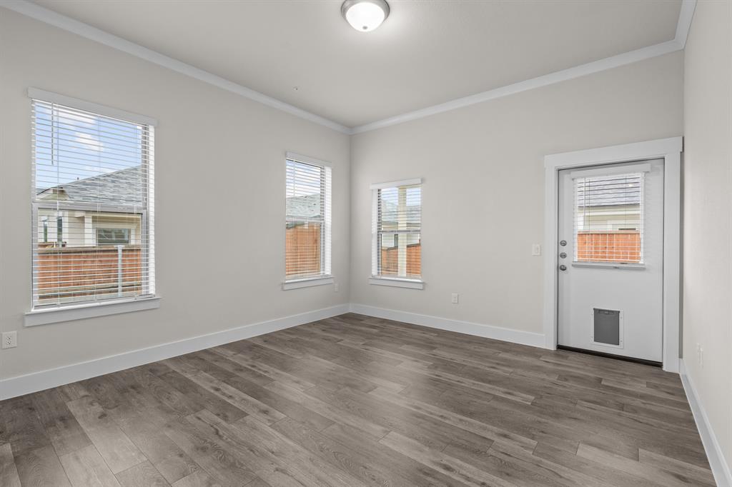3274 Ganzer Road West, Unit 102B Denton, TX 76207 - Photo 11 of 22 a view of an empty room with wooden floor and a window