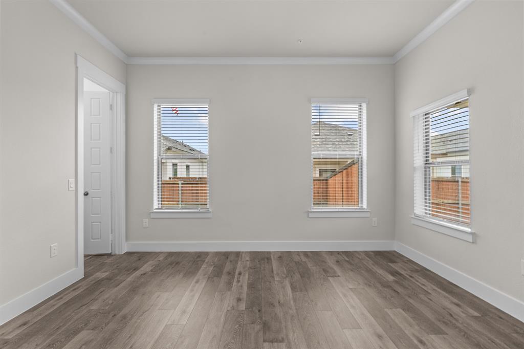 3274 Ganzer Road West, Unit 102B Denton, TX 76207 - Photo 12 of 22 an empty room with wooden floor and windows
