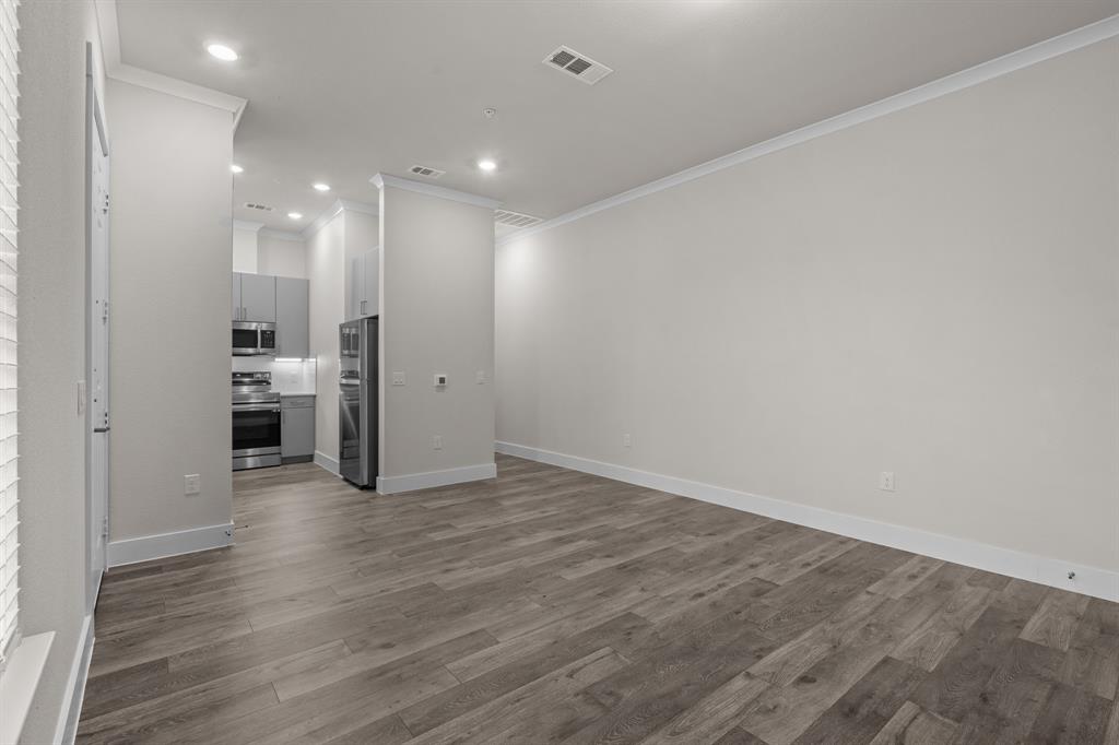 3274 Ganzer Road West, Unit 102B Denton, TX 76207 - Photo 3 of 22 an empty room with wooden floor and white walls