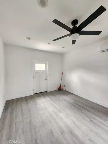 an empty room with a ceiling fan and window
