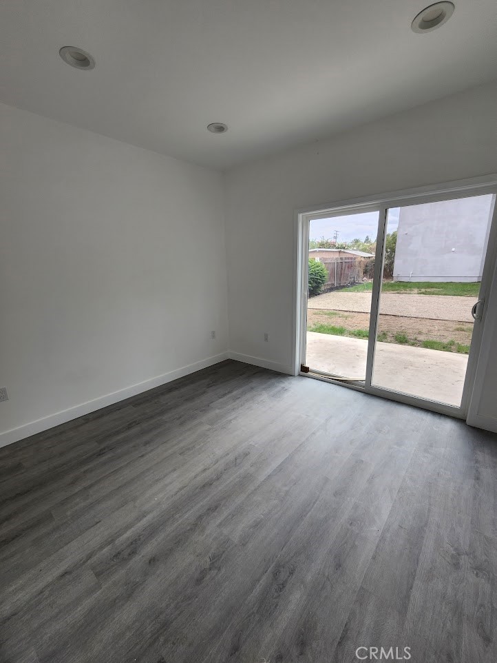 810 Quarry Street, Unit 2 Corona, CA 92879 - Photo 4 of 7 an empty room with wooden floor and windows
