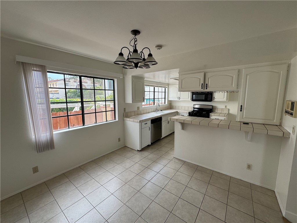 526 South Catalina Avenue, Unit C Redondo Beach, CA 90277 - Photo 8 of 29 a kitchen with a stove a sink and a microwave