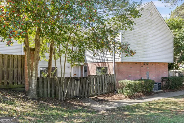 a view of a house with a small yard and wooden fence