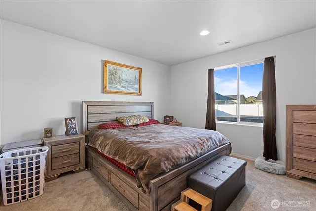 a bed sitting in a bedroom next to a window