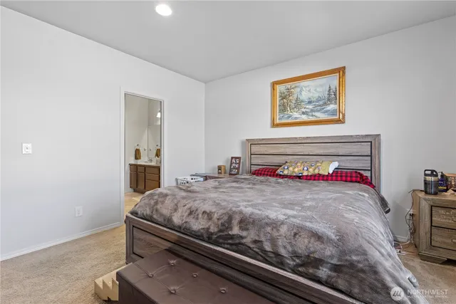 a bedroom with a bed and painting on the wall