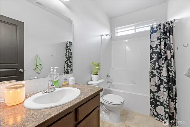 a bathroom with a sink a toilet a tub and shower