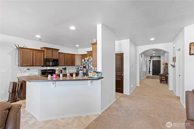 a view of a living room kitchen with stainless steel appliances cabinets