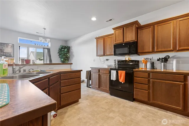 a kitchen with stainless steel appliances granite countertop a stove sink and cabinets