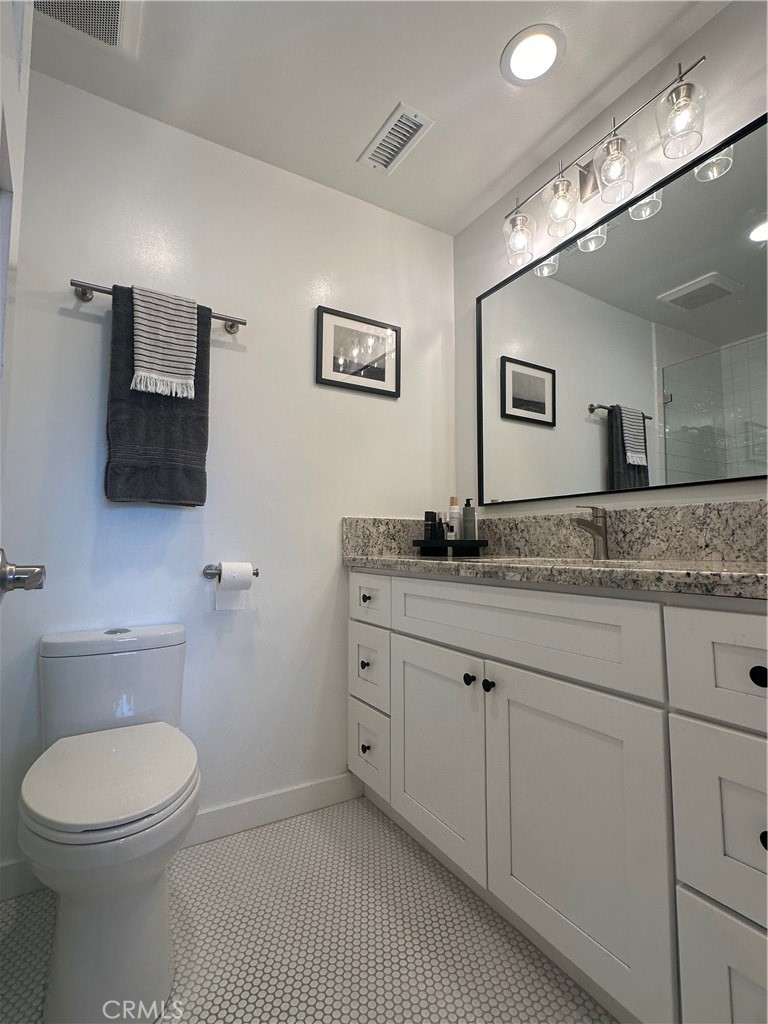 12100 Montecito Road Los Alamitos, CA 90720 - Photo 18 of 25 a bathroom with a granite countertop toilet sink and mirror