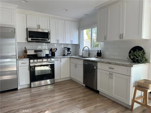 a kitchen with white cabinets and stainless steel appliances