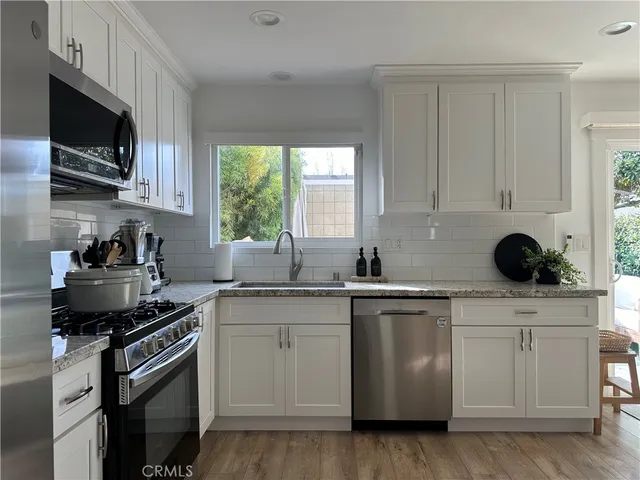 a kitchen with stainless steel appliances granite countertop a sink a stove a microwave and cabinets