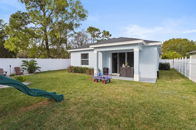 a view of a house with backyard and sitting area