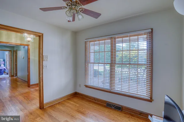 a view of an empty room with window and wooden floor