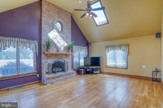 a view of a room with wooden floor and kitchen view