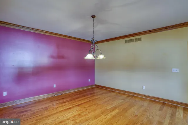 an empty room with windows and ceiling fan