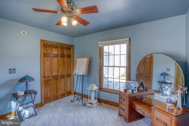 a bedroom with a bed and a ceiling fan