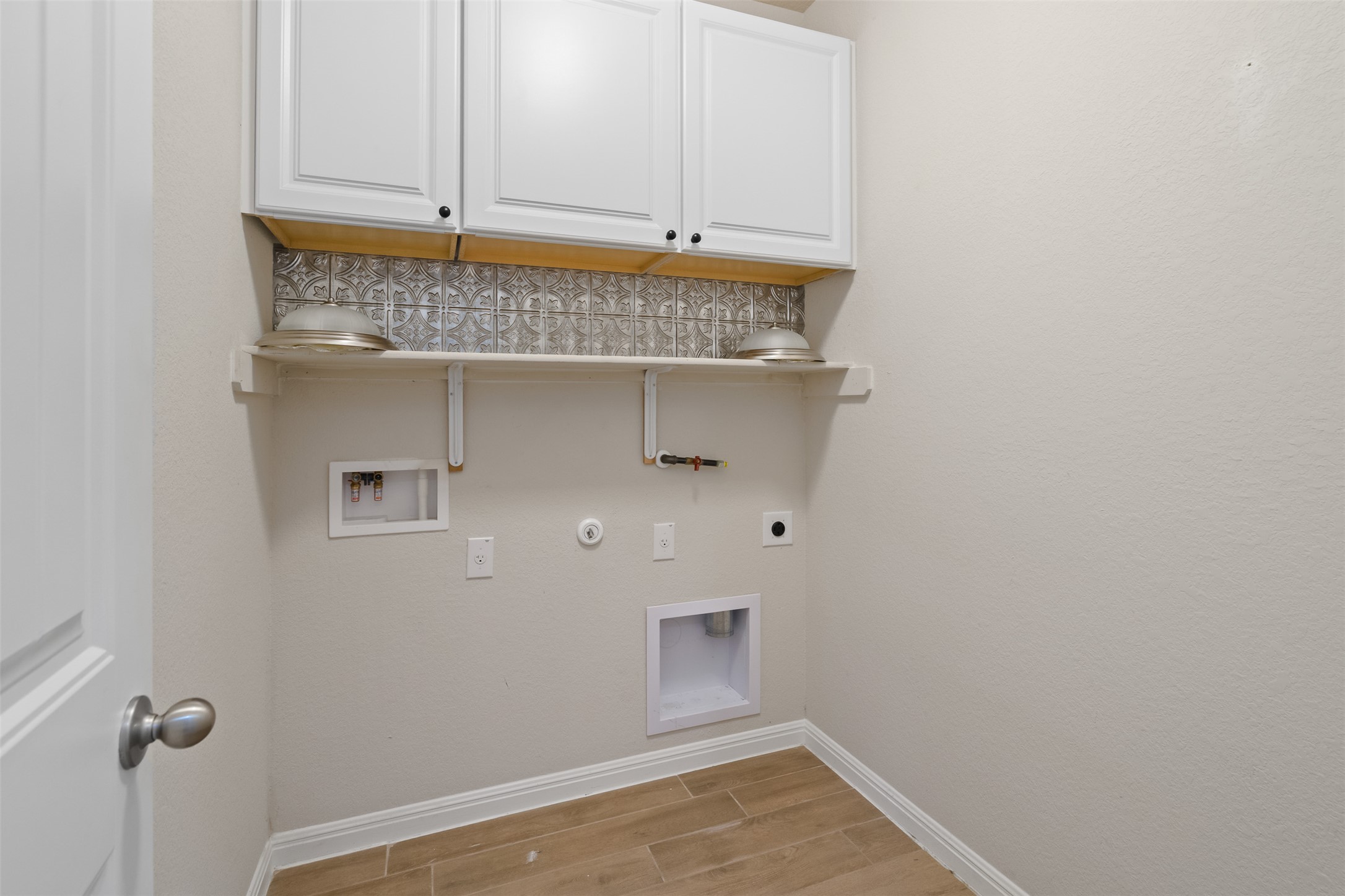 4125 Buffalo Ford Road Georgetown, TX 78628 - Photo 20 of 28 Laundry area with hookup for an electric dryer, hookup for a gas dryer, light wood-type flooring, washer hookup, and cabinet space