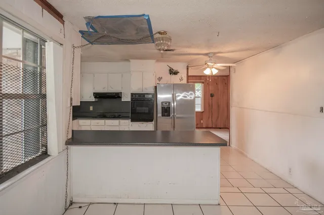 a view of a counter top space with stainless steel appliances granite countertop furniture and a window